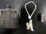 un porte-monnaie en argent et un dé à coudre en argent posés sur une table
