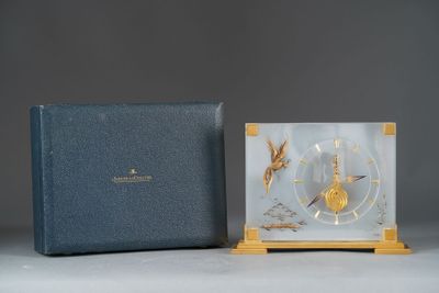 une image représentant une horloge posée sur une table, à côté d'une boîte