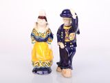 two figurines of a man and a woman standing next to each other