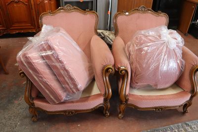 two pink chairs with bags on them in a room