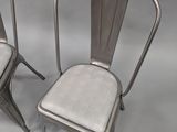 pair of metal chairs with upholstered seats on a white background