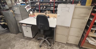un bureau avec une chaise et un réfrigérateur dans une pièce