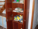 a book shelf with books on it in the corner of a room