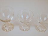 three empty wine glasses sitting on top of a white table