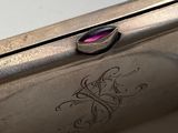 a close up of a silver cell phone with a pink glass