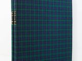 un livre à carreaux bleus et verts, avec une reliure dorée