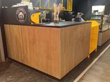 a coffee shop with a yellow counter and black walls