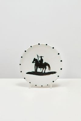 une assiette en noir et blanc représentant la silhouette d'un homme à cheval