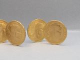 trois pièces d'or sont posées les unes à côté des autres sur une surface blanche