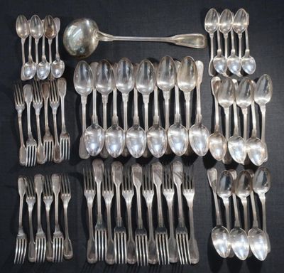 de nombreuses cuillères et fourchettes en argent disposées sur une table