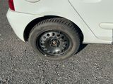 une petite voiture blanche avec un pneu crevé dans la rue