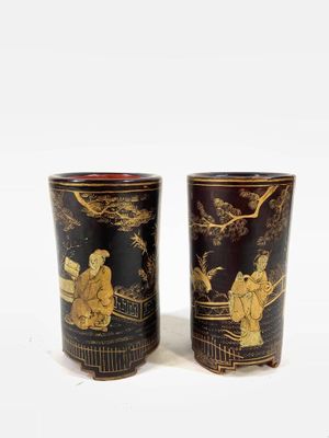 two black and gold vases sitting next to each other
