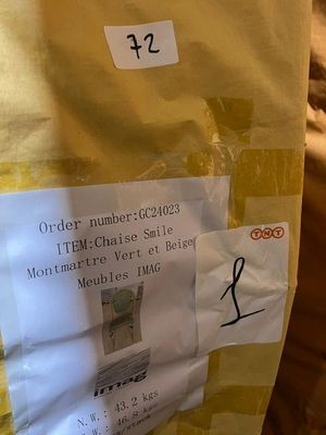 a bag of mail sitting on a bed with a sticker on it