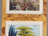 deux tableaux encadrés représentant une ville et un arbre, dans un cadre en bois
