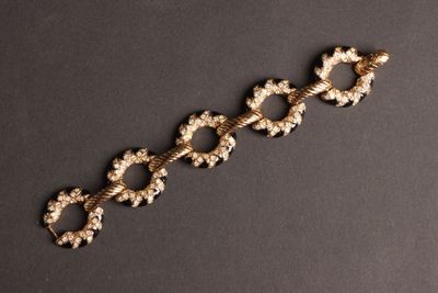 gros plan d'un bracelet en or sur une surface noire