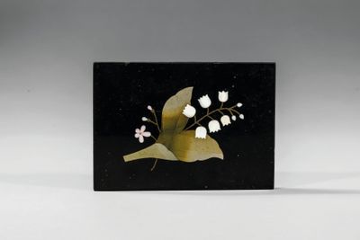 une carte noire et dorée ornée de fleurs blanches