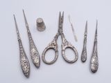 five pairs of scissors and a nail brush on a table