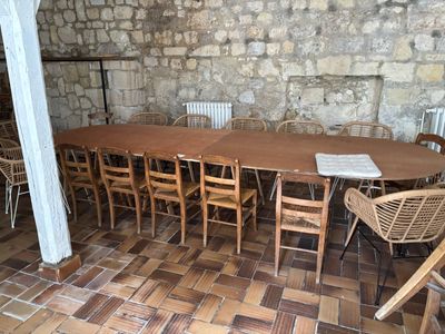 une table et des chaises dans une pièce avec un mur en pierre en arrière-plan