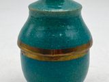 a blue vase with a gold rim sitting on a white surface