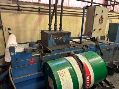 un fût vert posé sur une machine dans une usine