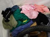 a pile of clothes and a bicycle tire in a room