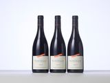 three bottles of wine sitting on top of a table next to each other