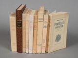 several old books are stacked on top of each other on a table