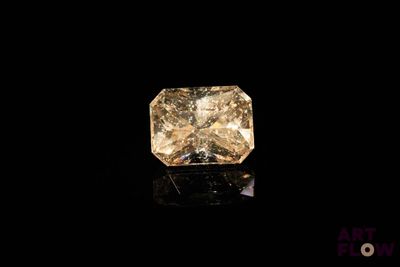 un diamant jaune sur une surface noire, avec un fond noir