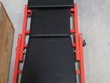 une photo d'une chaise noire et rouge dans un garage