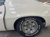 a white car that has a tire on the side of it