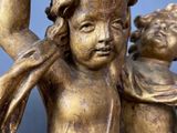 an antique bronze statue of a boy and a girl holding hands