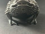 a close up of a metal frog sitting on a table