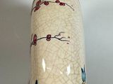 a white vase with a blue and red design on it