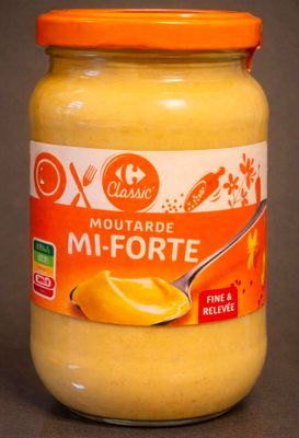 a jar of mustard with a spoon in it