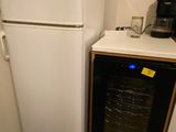 a white refrigerator and a black refrigerator freezer in a kitchen