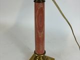 an old fashioned lamp with a red marble base and a brass base