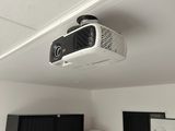 un projecteur fixé au plafond au-dessus d'un bureau d'ordinateur