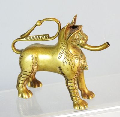 une statue en or représentant un lion avec une pipe dans la gueule