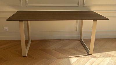 a wooden table with a metal base on a hard wood floor