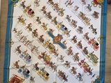 un gros plan sur un foulard carré bleu et blanc orné de chevaux et de calèches