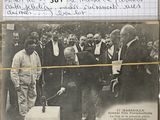 une vieille photo en noir et blanc montrant un groupe d'hommes en train de couper un ruban