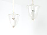 deux lampes en verre suspendues au plafond au-dessus d'un lit
