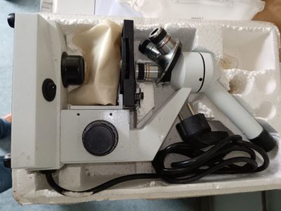 une boîte blanche contenant un microscope et un sèche-cheveux