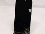 a broken cell phone sitting on a stand on a white surface