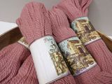 two skeins of pink yarn in a wooden bowl on a table