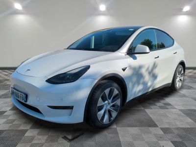a white tesla suv parked in a garage with a checkered floor