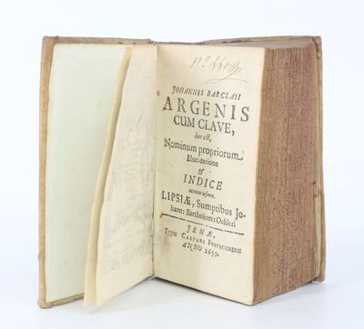 un livre ouvert posé sur une table, devant un fond blanc