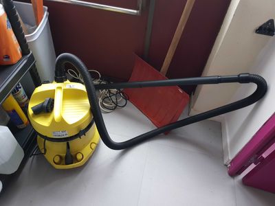 a yellow vacuum that is on the floor in a room