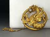 un collier en or orné d'un oiseau et d'un autre oiseau