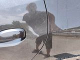a reflection of a skateboarder on the side of a car